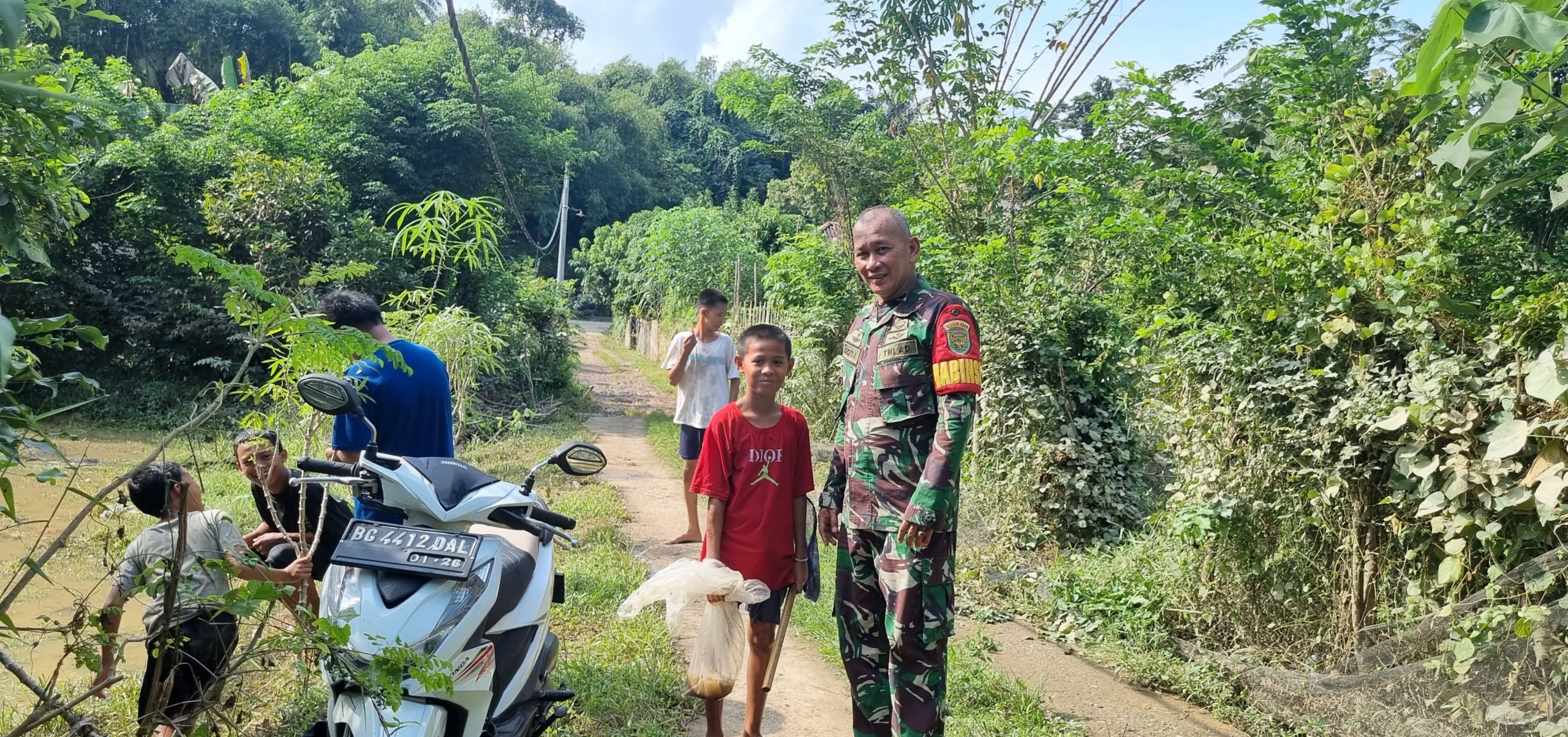 Babinsa Tegal Rejo Koramil 05/TE, Ikut Berbaur Bersama Anak-Anak Yang Cari Ikan