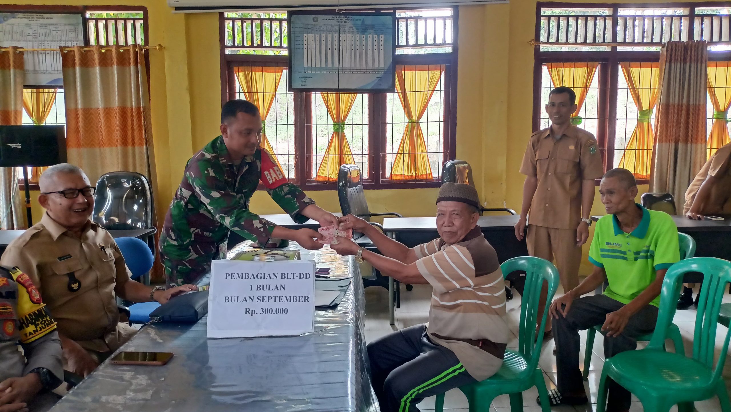 Dampingi Penyaluran BLT DD, Babinsa Paduraksa Sampaikan Pesan Kamtibmas
